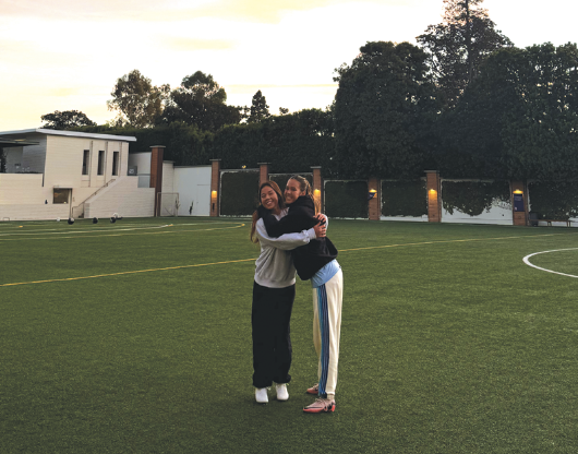 Varsity lacrosse players Jackie Lane ’26 and Enna Corley ’27 hug before a preseason practice.